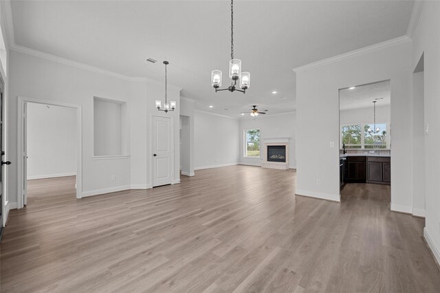 unfurnished living room featuring ceiling fan, light wood-type flooring, and ornamental molding