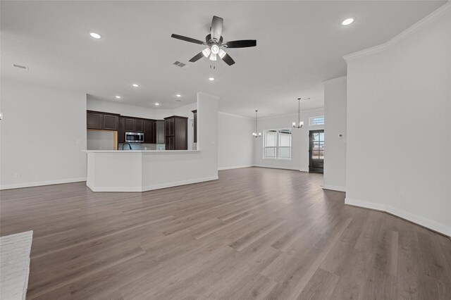 unfurnished living room with ceiling fan with notable chandelier, ornamental molding, and hardwood / wood-style flooring