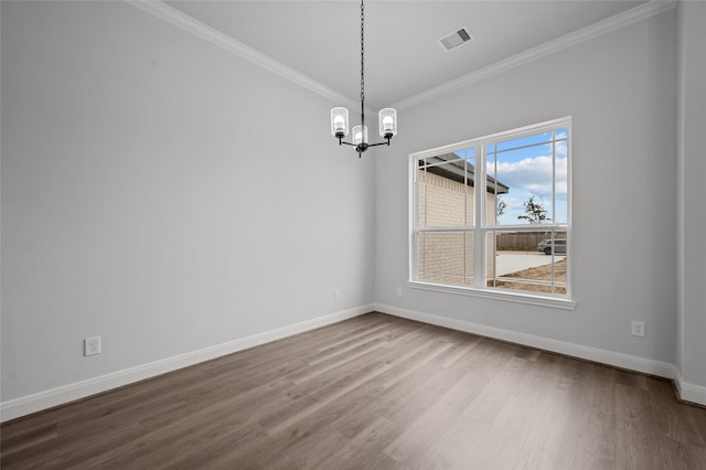 unfurnished dining area featuring ornamental molding, a notable chandelier, and wood-type flooring