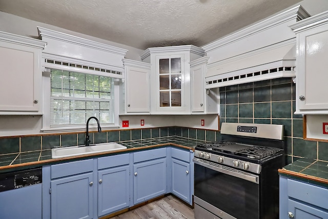 kitchen featuring sink, stainless steel gas stove, white cabinetry, and dishwasher