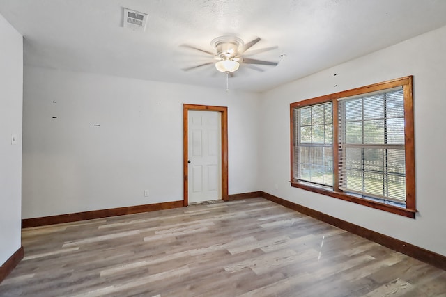 spare room with ceiling fan and light wood-type flooring