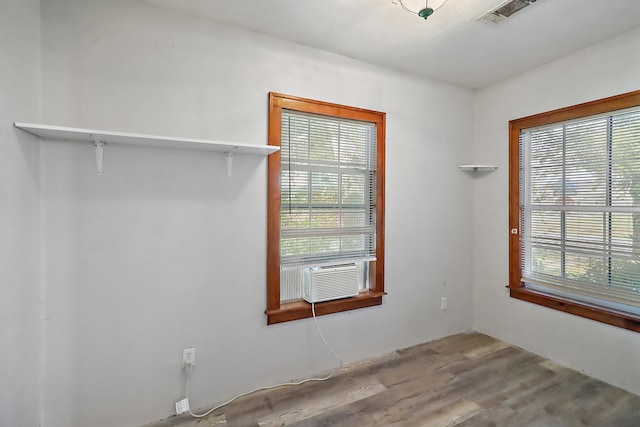 unfurnished room featuring light hardwood / wood-style flooring and cooling unit