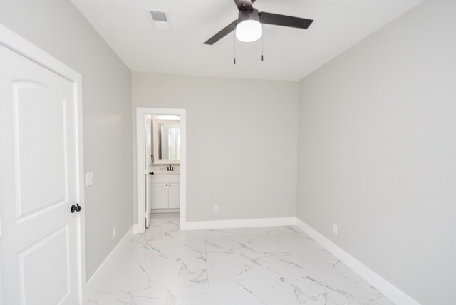 unfurnished bedroom with ceiling fan and connected bathroom