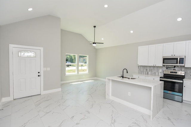 kitchen with an island with sink, appliances with stainless steel finishes, sink, and white cabinets