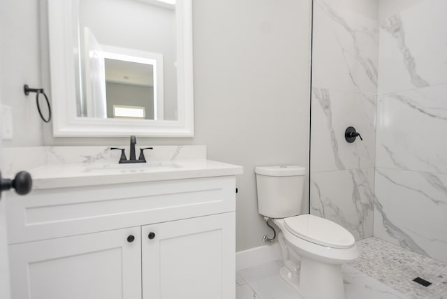 bathroom with vanity, toilet, and a tile shower