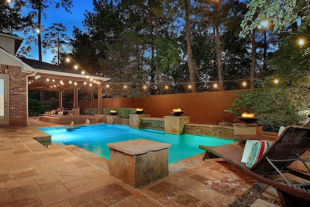 pool at dusk featuring a patio area