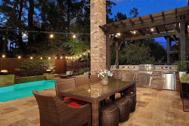 patio terrace at dusk featuring a fenced in pool, an outdoor kitchen, a pergola, and grilling area