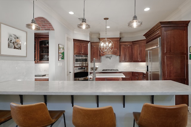 kitchen featuring decorative backsplash, ornamental molding, decorative light fixtures, and appliances with stainless steel finishes