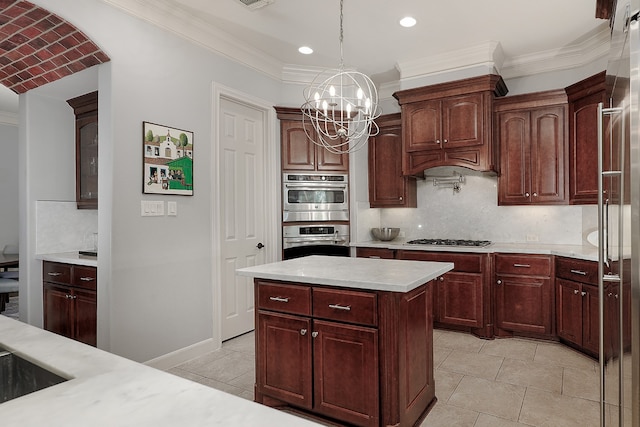 kitchen with hanging light fixtures, tasteful backsplash, a kitchen island, stainless steel appliances, and a notable chandelier