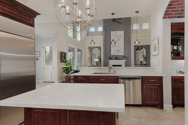 kitchen with a kitchen island with sink, ceiling fan with notable chandelier, sink, stainless steel appliances, and light tile patterned floors