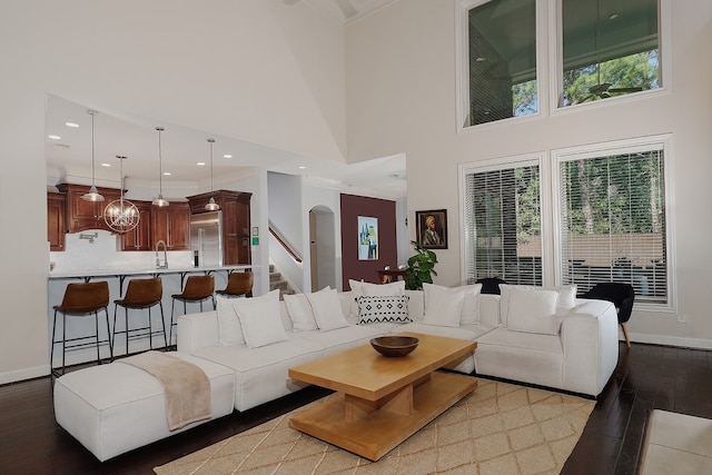 living room with light wood-type flooring, a wealth of natural light, and a towering ceiling