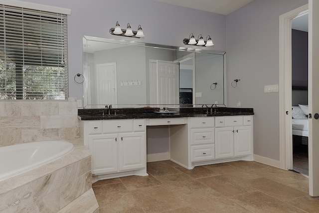 bathroom featuring a relaxing tiled tub and vanity