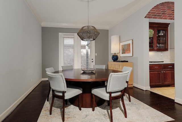 dining area with dark hardwood / wood-style floors and ornamental molding