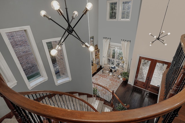 foyer with a high ceiling, a notable chandelier, and dark hardwood / wood-style flooring