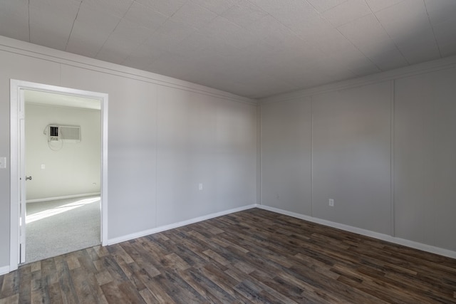 spare room with a wall unit AC and dark hardwood / wood-style floors