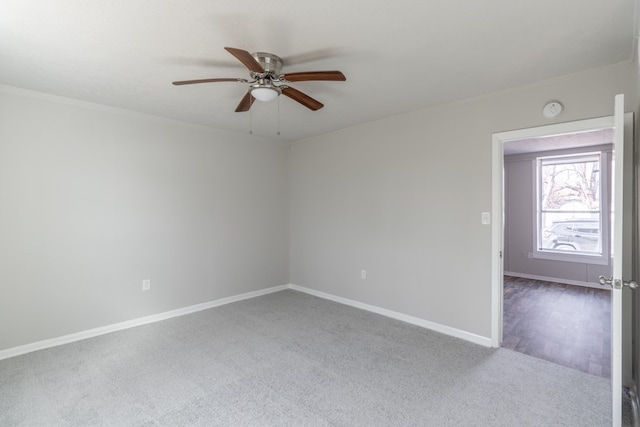 carpeted spare room featuring ceiling fan