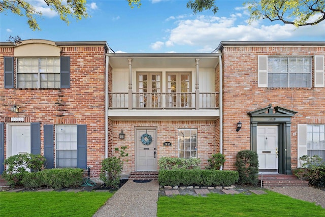 townhome / multi-family property featuring a front yard and a balcony