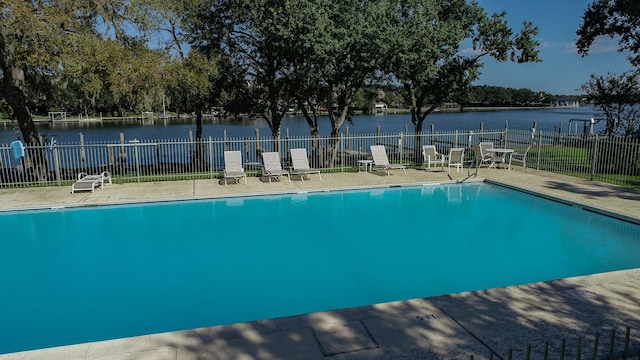 view of swimming pool with a patio and a water view