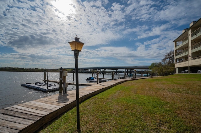 view of dock featuring a yard and a water view