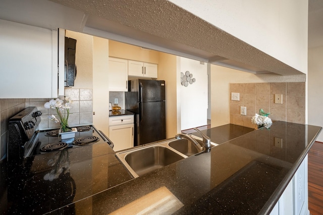 kitchen featuring decorative backsplash, kitchen peninsula, sink, black appliances, and white cabinets