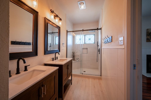 bathroom with vanity, a shower with shower door, and wood-type flooring