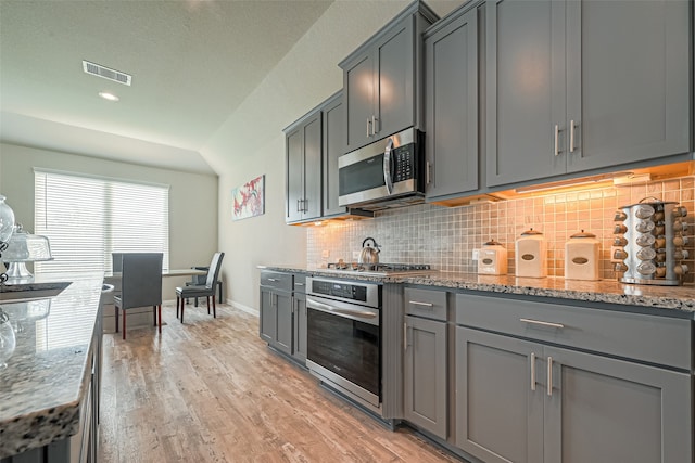 kitchen with stainless steel appliances, gray cabinetry, and light wood-type flooring