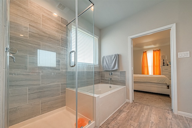 bathroom featuring hardwood / wood-style flooring and independent shower and bath