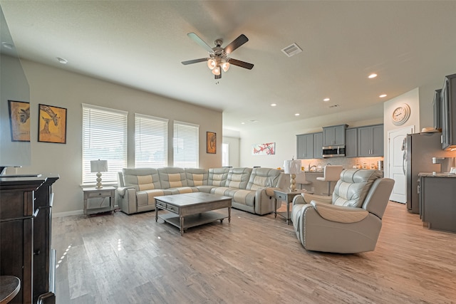 living room featuring light hardwood / wood-style floors and ceiling fan