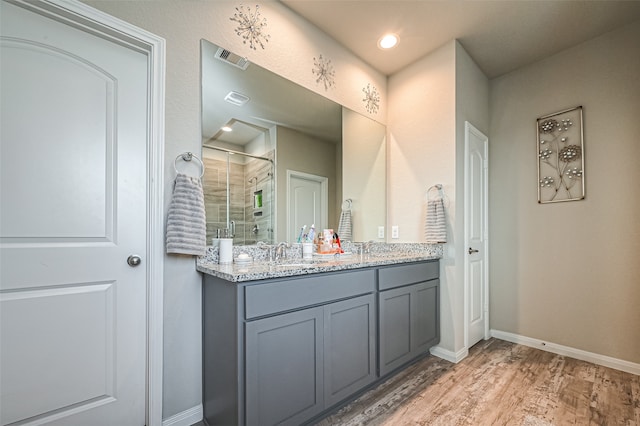 bathroom with walk in shower, vanity, and wood-type flooring