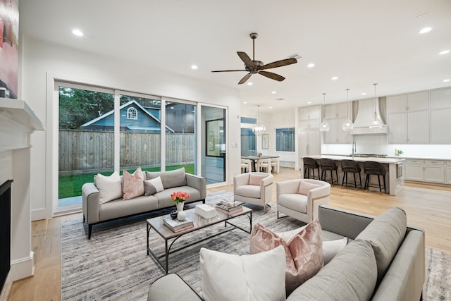 living room featuring ceiling fan and light hardwood / wood-style flooring