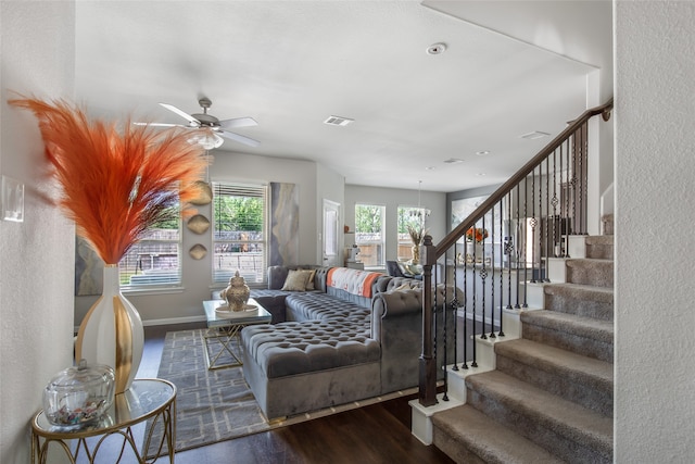 living room with ceiling fan with notable chandelier and hardwood / wood-style flooring