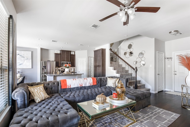 living room featuring dark wood-type flooring and ceiling fan