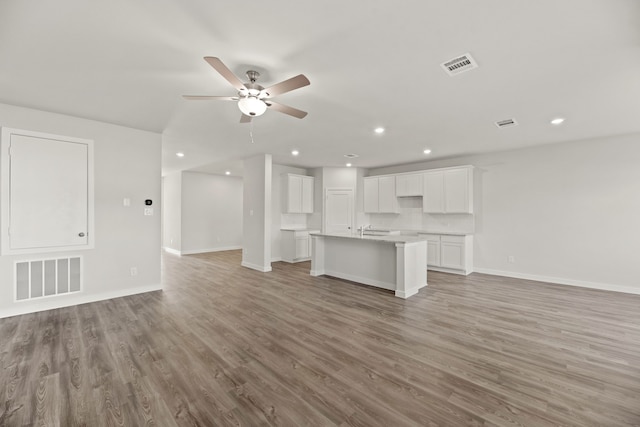 unfurnished living room featuring wood-type flooring and ceiling fan