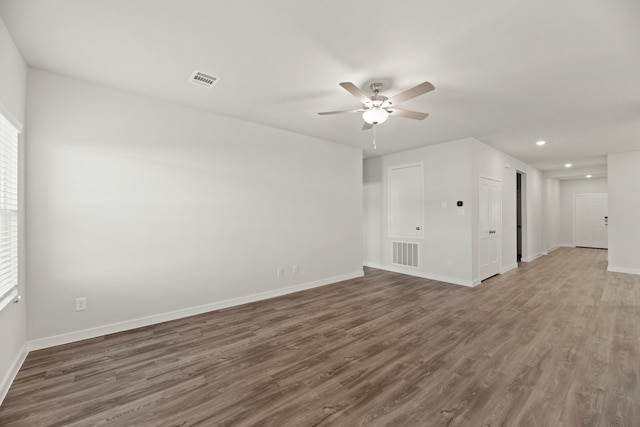 empty room with ceiling fan and dark hardwood / wood-style flooring