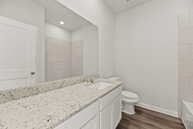 bathroom featuring vanity, wood-type flooring, and toilet