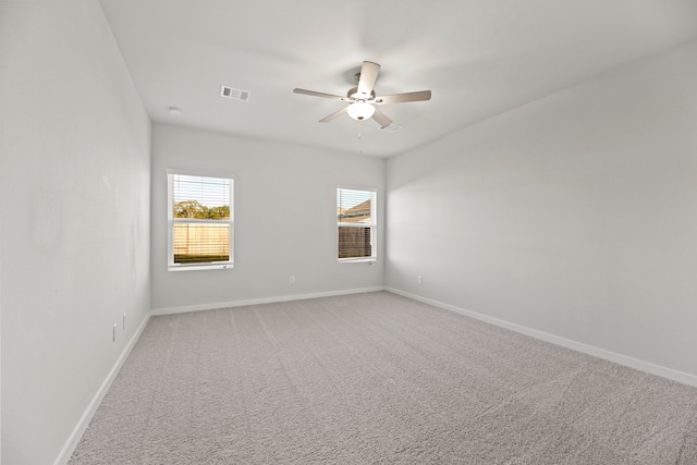 carpeted spare room with ceiling fan