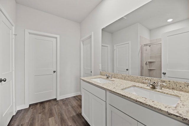 bathroom featuring vanity, wood-type flooring, and walk in shower