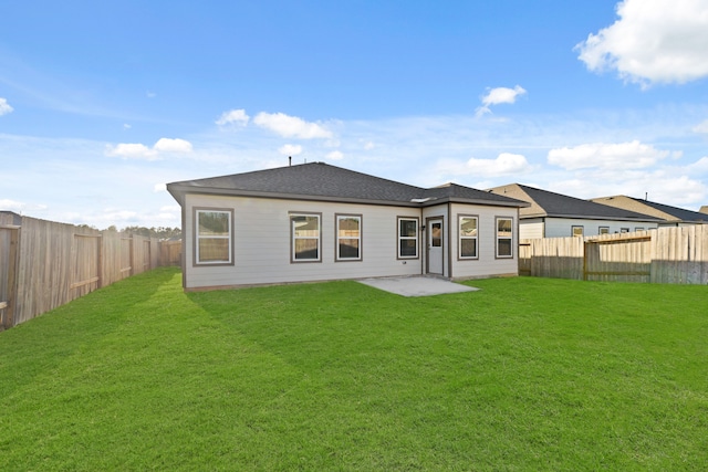 rear view of house with a patio and a lawn