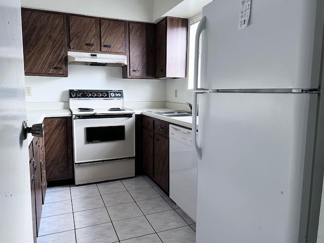 kitchen with white appliances, under cabinet range hood, dark brown cabinetry, light countertops, and a sink