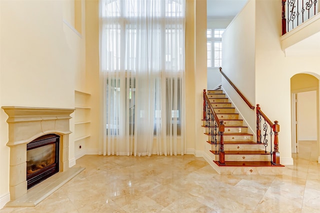 interior space with a towering ceiling and a tile fireplace