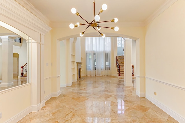 hallway featuring ornate columns, crown molding, and a notable chandelier