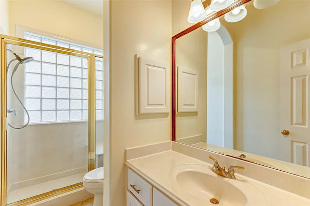 bathroom featuring walk in shower, vanity, and toilet