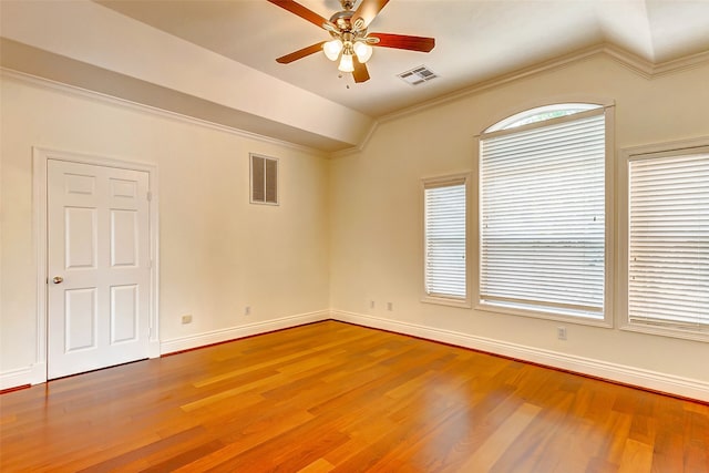 unfurnished room with ornamental molding, hardwood / wood-style flooring, plenty of natural light, and vaulted ceiling