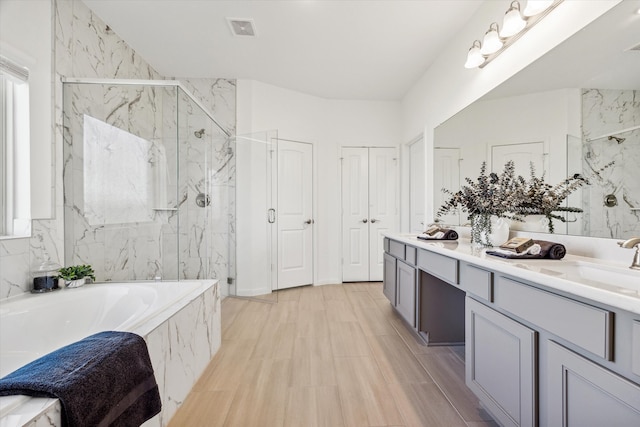 bathroom featuring independent shower and bath and vanity