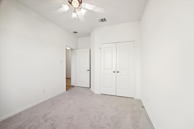 unfurnished bedroom with light carpet, a closet, and ceiling fan