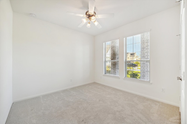 carpeted spare room with ceiling fan