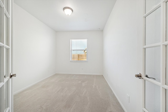 unfurnished room featuring light carpet