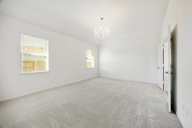 carpeted spare room with a notable chandelier