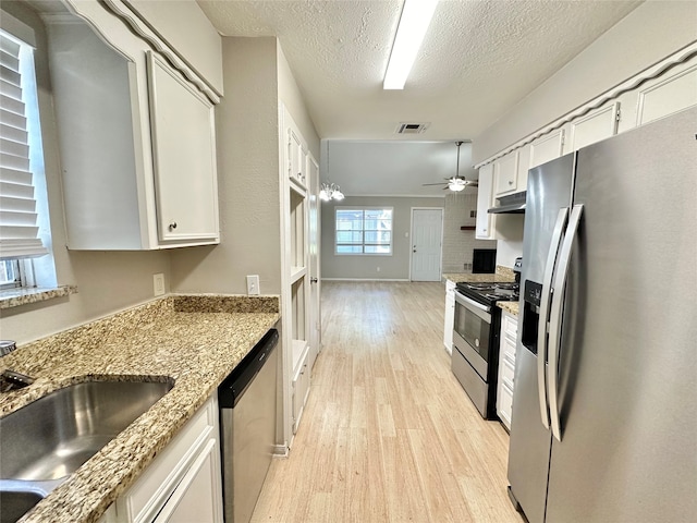 kitchen featuring white cabinets, sink, a textured ceiling, appliances with stainless steel finishes, and light wood-type flooring