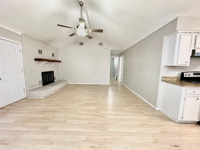 unfurnished living room with ceiling fan, light hardwood / wood-style flooring, a brick fireplace, and vaulted ceiling